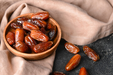 Plate with sweet dates on dark background