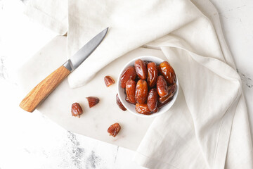 Bowl with sweet dates on table