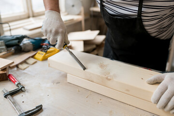 Carpenter working with wood in workshop. Joinery work on the production and renovation of wooden furniture. Small Business Concept