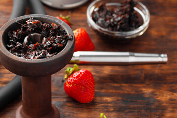 Hookah parts and strawberry on gray surface close up