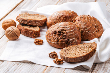 Side view on rye walnut bread on the wooden decorated table