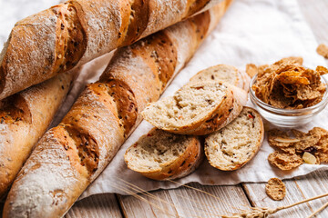 Naklejka premium Top view on cereal baguette loafs on the wooden decorated background