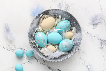 Plate with beautiful Easter eggs on light background