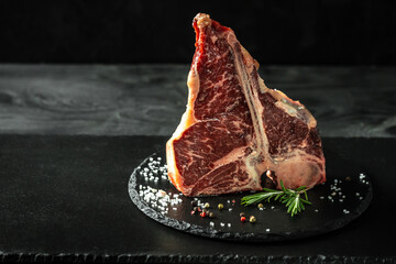 raw porterhouse steak or Fed T Bone Steak dry aged of beef Ready to Cook on slate board and woden...