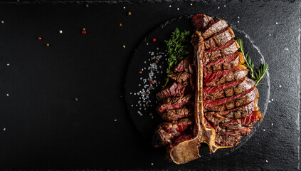 Barbecue dry aged wagyu porterhouse steak, grilled medium rare beef steak with spices served on slate board. sliced. Long banner format, top view - obrazy, fototapety, plakaty