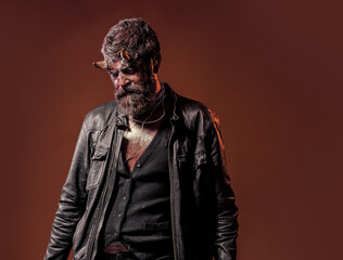 Halloween hell, danger. Demon with beard, wounds, red blood on brown background. Man with satan...