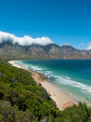 Fototapeta premium Incredible views of Kogel Bay Beach with the cloud covered Kogelberg Mountain Range forming a beautiful backdrop. Overberg. Western Cape. South Africa