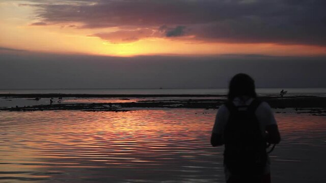 Photographer taking pictures of a beautiful sunset in Bali beach