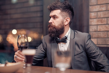Business drinking wine at luxury cafe. Confident man sitting at bar alone.