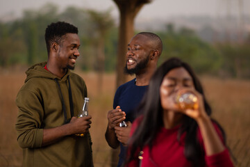 friends together outdoor at a party, having drinks, discussing