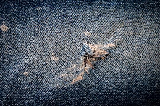 Jeans. Ripped Destroyed Torn Blue Jeans Background. Close Up Blue Jean Texture