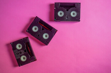 Vintage mini DV cassette tapes on pink background