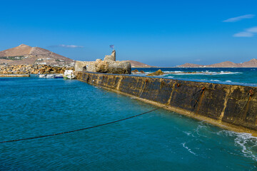 Traditional Cycladitic view with moored traditional fishing boatson a windy day at the picturesque...