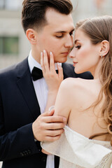 Naklejka premium beautiful, gentle and happy bride and groom. woman gently touches man's face