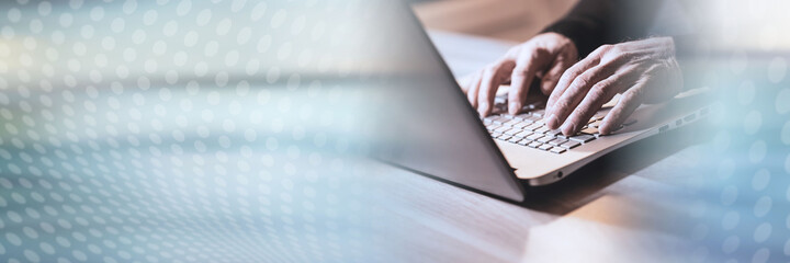 Hands typing on laptop keyboard; panoramic banner