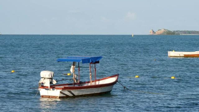 Tranquil blue sea bay with fisherman's boats. Small calm waves