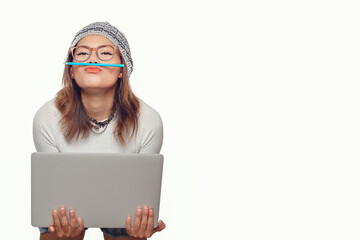  Asian woman holds her laptop in a fun mood.