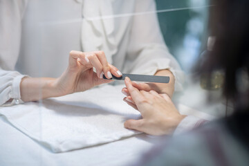 Close up picture of nail artists hands doing manicure