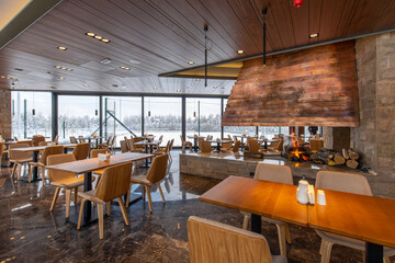 Interior of an empty mountain restaurant with large fireplace in the middle