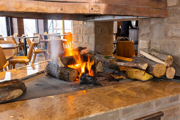 Fire, wood logs, burning in the fireplace in mountain restaurant