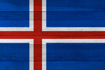 Fototapeta premium Iceland national flag painted on a wooden plank background.