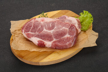 Raw pork steak over wooden board