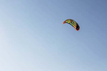 Bright colored parachute from kite surfing in the blue sky. Place for text