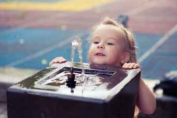 baby girl looks at the drinking fountain 