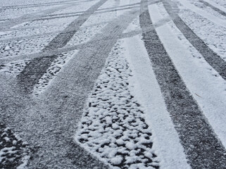 アスファルトに積もった雪の上の轍