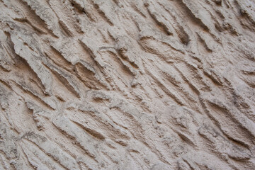 close up of old grunge brown painted wall with waves on it. Interior background. Stone surface. 