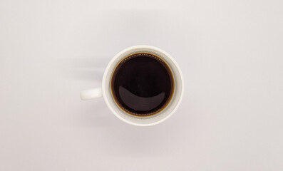 White cup with coffee. White cup of coffee top view. White cup of coffee on a white background top view.
