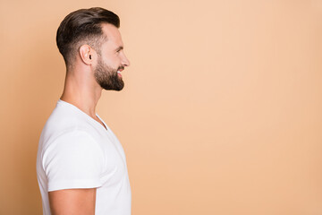 Profile side photo of young handsome man happy positive smile look empty space isolated over beige...