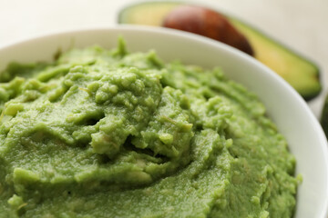 Bowl of guacamole and avocado, close up