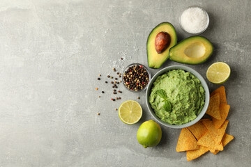 Concept of tasty eating with guacamole and ingredients on gray background