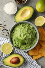 Concept of tasty eating with guacamole and ingredients on gray background