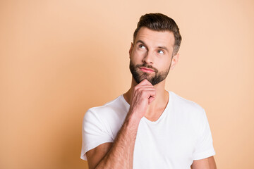 Photo of young handsome man dream dreamy curious look empty space hand touch chin isolated over...