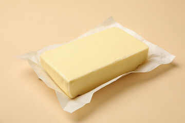 Paper with butter on beige background, close up