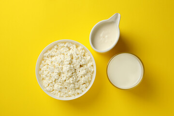 Different fresh dairy products on yellow background, top view