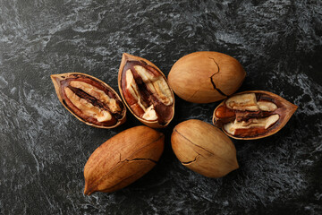 Tasty pecan nuts on black smokey background