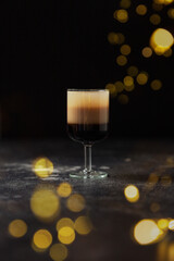 B52 cocktail at dark festive background. Bokeh lights around