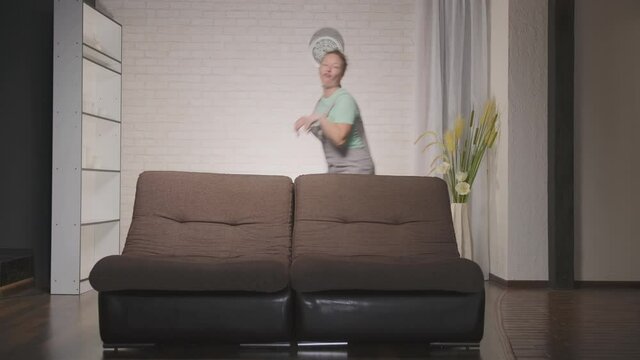 Funny woman having fun portraying bunny jumping at home in living room.