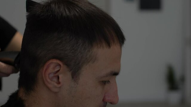 Barber cutting hair with clipper