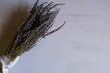 bunch of dried lavender tied with textile and white bow close-up on white background. Bouquet making. Copy space	
