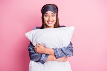 Photo portrait of amazed girl hugging pillow isolated on pastel pink colored background