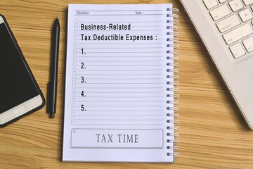 Text on notepad with laptop and smartphone on wooden table