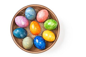 Different easter eggs in ceramic bowl on white