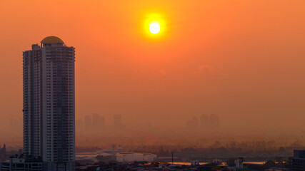 The blurred abstract background of the morning sun exposure to the tiny dust particles that surround the tall buildings in the capital, the long-term health issue of pollution.