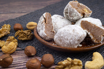 Chocolate walnut truffles, powdered sugar dairy sweets with walnuts, cashew fudge, sweet dessert