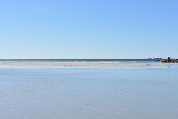 Idyllic empty beach background with lake, turquoise water, blue sky and horizon over water. Rias Baixas, Galicia, Spain.