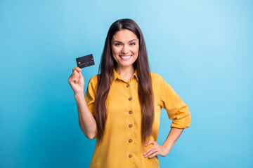 Photo portrait of business woman smiling keeping bank card with salary savings isolated on bright blue color background